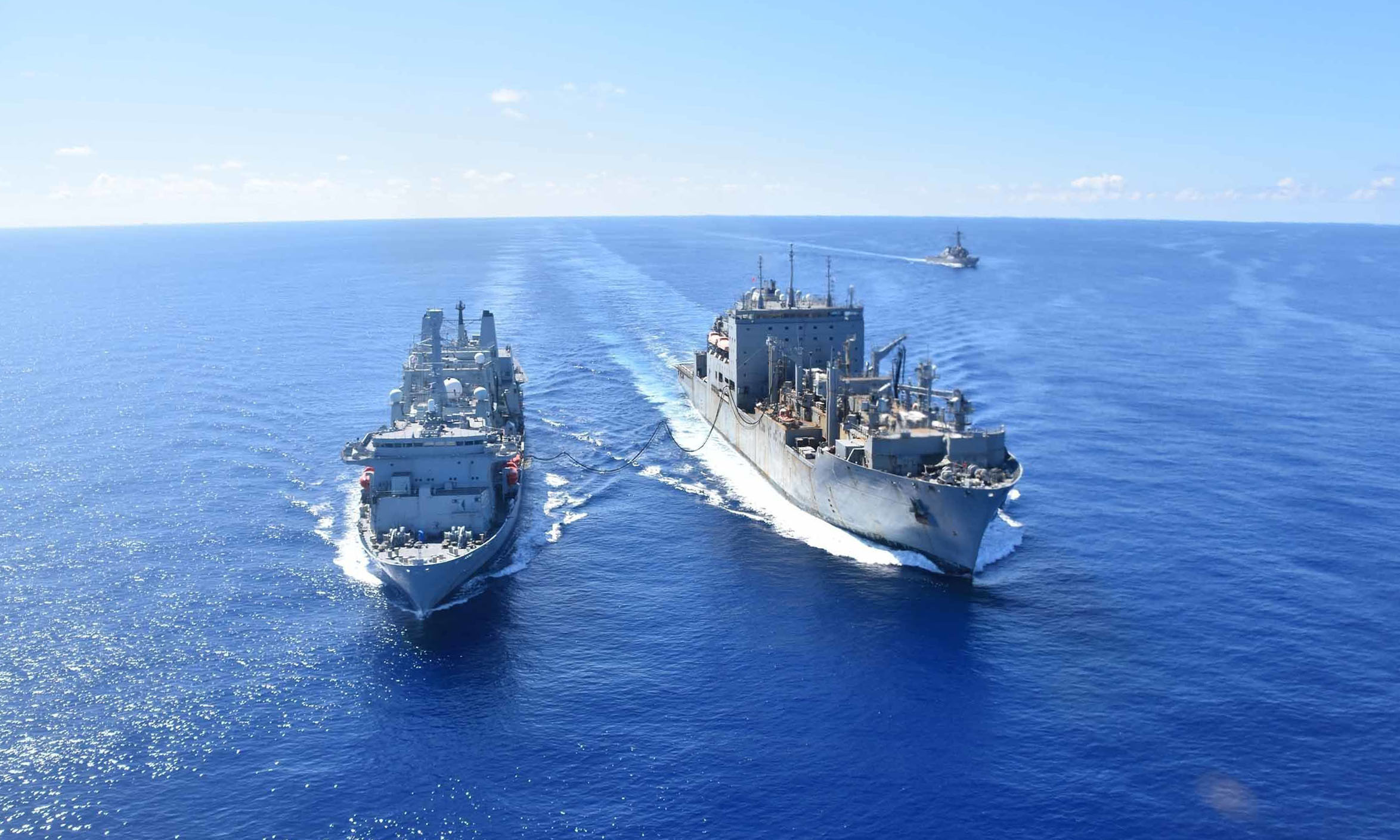 USNS Alan Shepard (T-AKE 3), left, conducts an underway replenishment with RFA Fort Victoria (A 387) while USS The Sullivans (DDG 68) follows in the East China Sea.