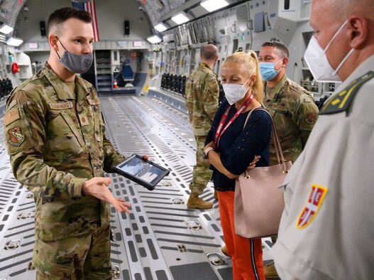 Maj. Joshua Burkhardt (left), of the U.S. Air Force School of Aerospace Medicine’s Critical Care Air Transport Team, briefs a Serbian armed forces medical delegation in the school’s C-17 Globemaster III fuselage Aug. 19 on the best practices developed for transport of COVID-19 patients on aircraft.