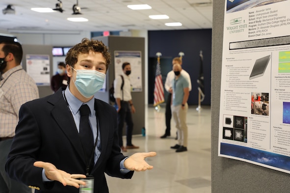 Wright State University student intern Alexander Vehre explains his poster. Vehre is an undergraduate majoring in mechanical engineering. (U.S. Air Force photo/Micah Hung)