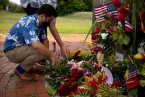 Patrick Pihana Branco, Hawaii state representative, arranges floral bouquets brought by local community members at the Pacific War Memorial during a ceremony held in remembrance of the fallen aboard MCBH, Aug. 29, 2021. In support of the 13 service members who lost their lives in Afghanistan, members of the community brought flowers to later be placed at the Pacific War Memorial for a small, private ceremony. (U.S. Marine Corps photo by Gunnery Sgt. Orlando Perez)