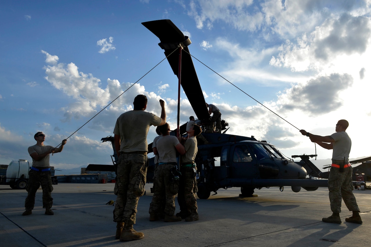 Airman perform maintenance on a helicopter.