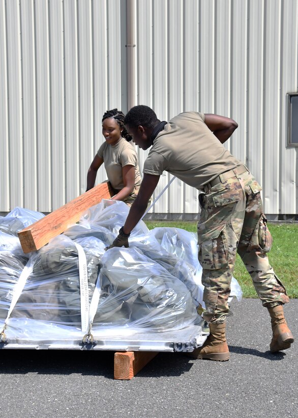 Airman 1st Class Jennifer Joseph and Senior Airman Joshua Tekpeh, 104th Logistics Readiness Squadron materials handlers, secure a pallet during a mobility exercise August 13, 2021, at Barnes Air National Guard Base, Massachusetts. The exercise was in progress August 9-15 and served as a practice opportunity for members to evaluate capabilities of their squadrons in the event of a base-wide mobilization. (U.S. Air National Guard photo by Staff Sgt. Sara Kolinski)