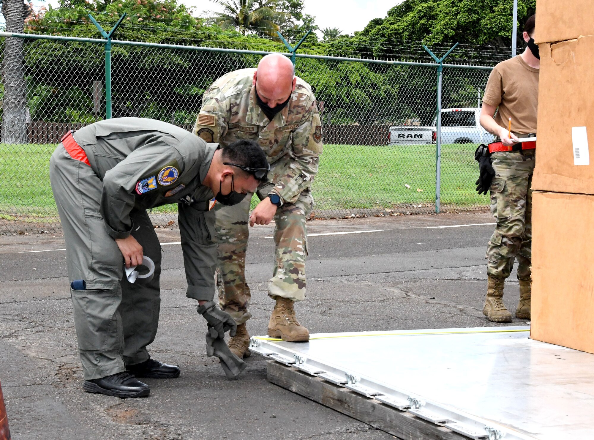 Two men examine part of a pallet.