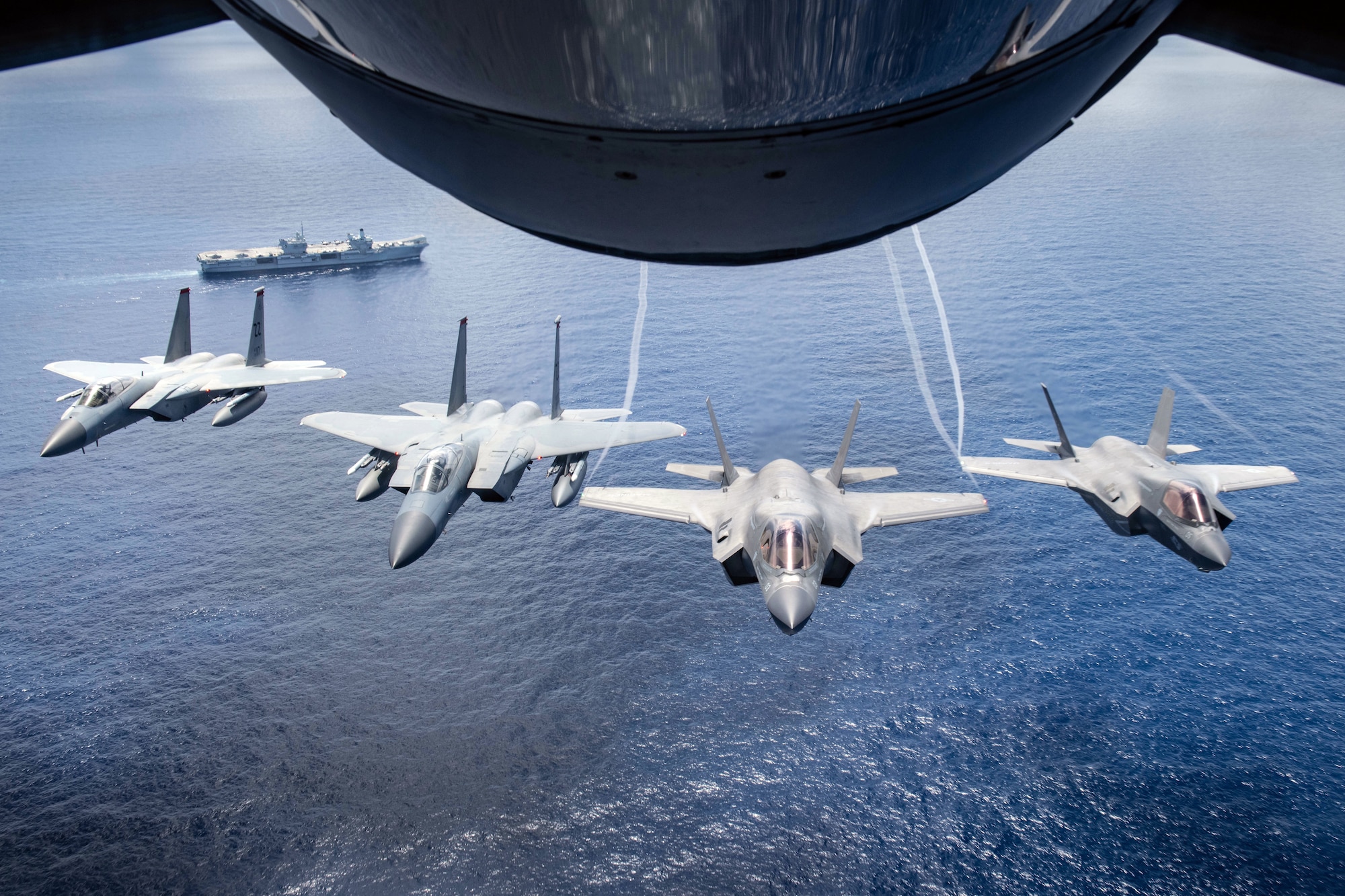 Two U.S. Marine Attack Squadron 211 F-35B Lightning IIs and two U.S. Air Force F-15 Eagles assigned to the 67th Fighter Squadron, fly over United Kingdom aircraft carrier HMS Queen Elizabeth over the west Indo-Pacific region