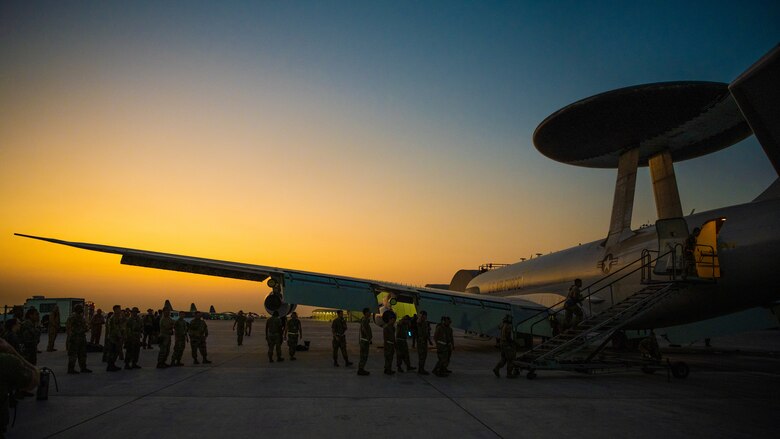 Airmen celebrate next to an E-3 Sentry aircraft