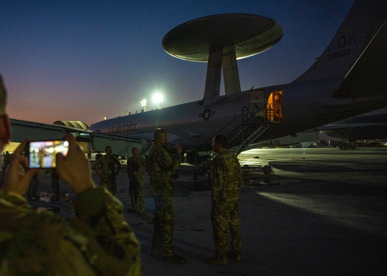 Airmen celebrate next to an E-3 Sentry aircraft