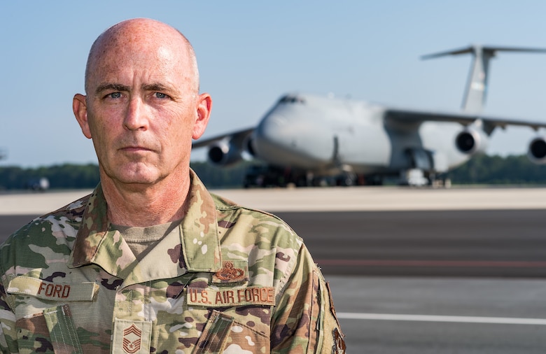 Chief Master Sgt. Bryan “Skip” Ford, 512th Aircraft Maintenance Squadron superintendent, poses for a photo near the flight line near a C-5M Super Galaxy on Dover Air Force Base, Delaware, Aug. 25, 2021. Ford recently recalled the events of Sept. 11, 2001, while stationed at Dover AFB and how 9/11 changed how he viewed our relative security and freedom as a nation. (U.S. Air Force photo by Roland Balik)