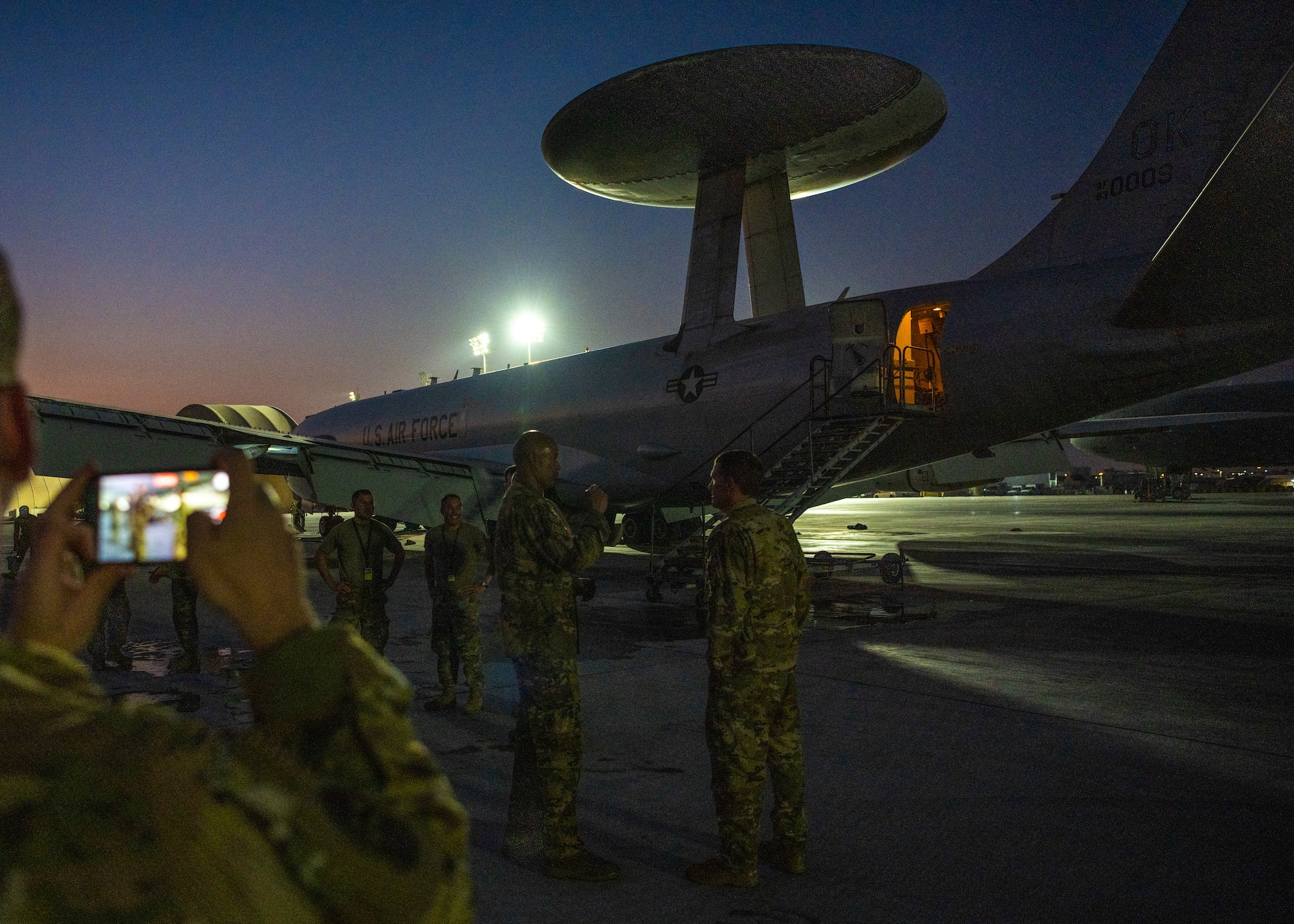 Airmen celebrate next to an E-3 Sentry aircraft