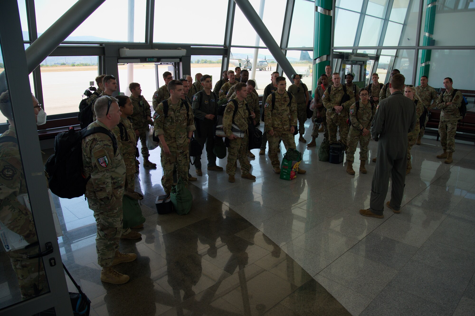 Airmen huddle in airport.