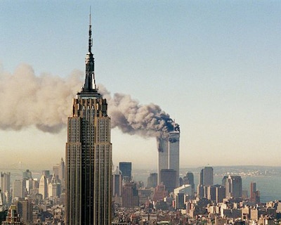 Smoke plumes from a high-res building with buildings surrounding it.