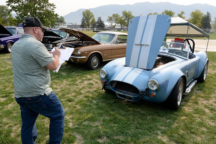Event judge Jeff Hall writes on a clipboard while judging a 1965 Shelby Cobra.