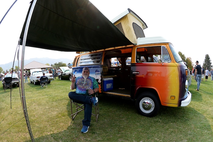 Brian Galligan sits in a chair under the awning of his 1976 Volkswagen Type 2 Campmobile.