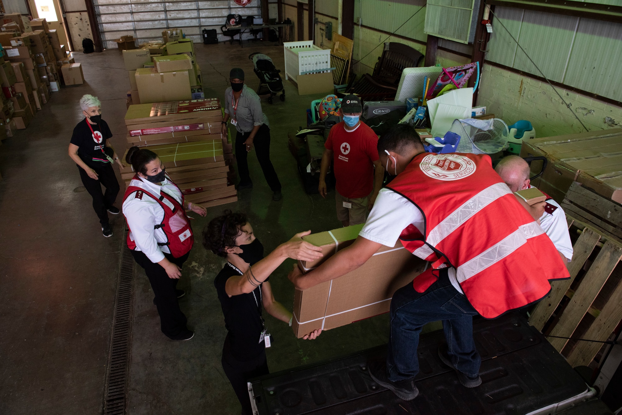 Volunteers from the Salvation Army and the Red Cross unload shelves in a warehouse at Holloman Air Force Base, New Mexico, Sept. 4, 2021. The Department of Defense, through U.S. Northern Command, and in support of the Department of State and Department of Homeland Security, is providing transportation, temporary housing, medical screening, and general support for at least 50,000 Afghan evacuees at suitable facilities, in permanent or temporary structures, as quickly as possible. This initiative provides Afghan evacuees essential support at secure locations outside Afghanistan. (U.S. Air Force photo by Staff Sgt. Kenneth Boyton)