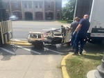 A New York Police Department parking enforcement vehicle that was crushed when the Twin Towers of the World Trade Center collapsed in Manhattan on 9/11 is unloaded outside the New York State Military Museum in Saratoga Springs, New York, Aug. 16, 2021. The vehicle, on loan from the New York State Museum, will be part of an exhibit at the museum, run by the New York State Division of Military and Naval Affairs, on the events of Sept. 11, 2001.