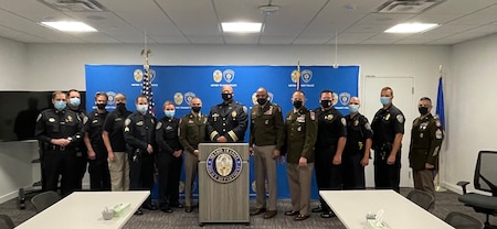 Policemen and women standing behind a podium for a photo.