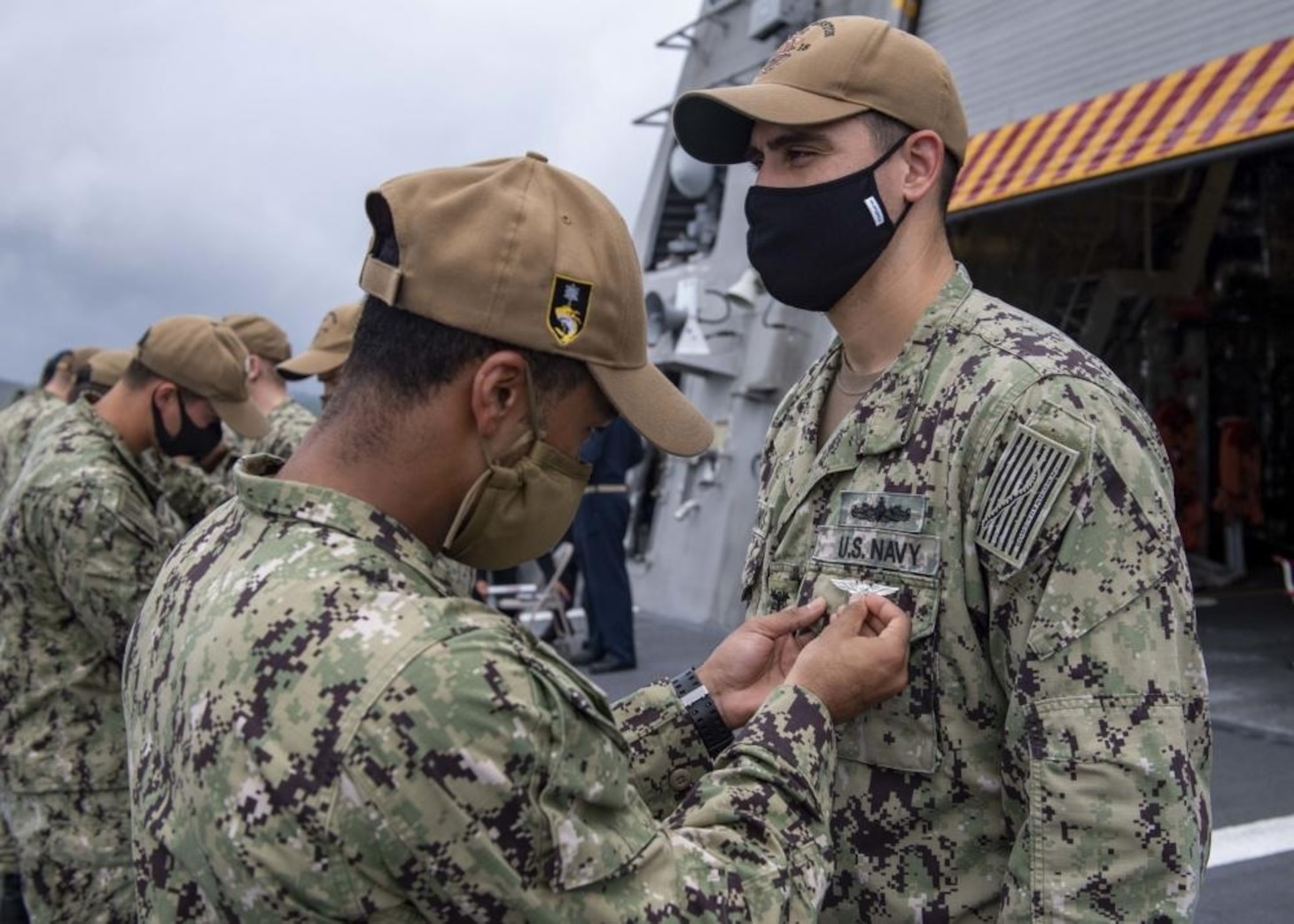 210831-N-WU807-1159 APRA HARBOR, Guam (Aug. 31, 2021) Master Chief Damage Controlman Christian Bolanos, right, from Buga, Colombia, receives the Enlisted Air Warfare Specialist (EAWS) pin from Chief Engineman Jaron White, from Victorville, Calif., during an award ceremony aboard Independence-variant littoral combat ship USS Charleston (LCS 18), Aug. 31. Charleston, part of Destroyer Squadron Seven, is on a rotational deployment operating in the U.S. 7th Fleet area of operation to enhance interoperability with partners and serve as a ready-response force in support of a free and open Indo-Pacific region. (U.S. Navy photo by Mass Communication Specialist 2nd Class Adam Butler)