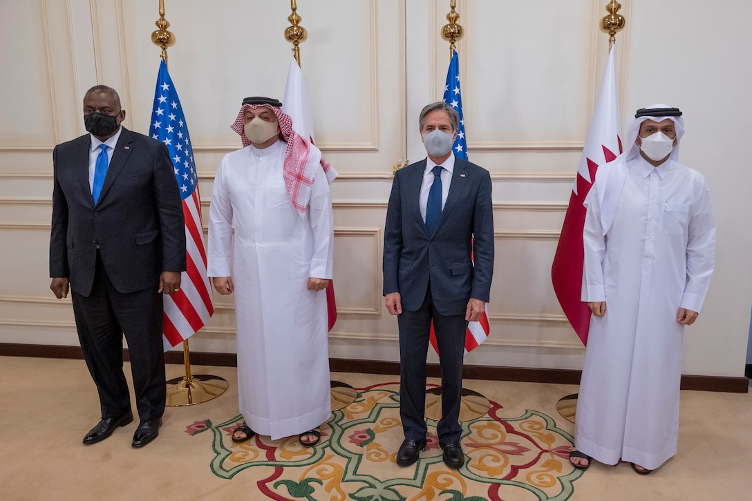 Four people stand in a row in a briefing.