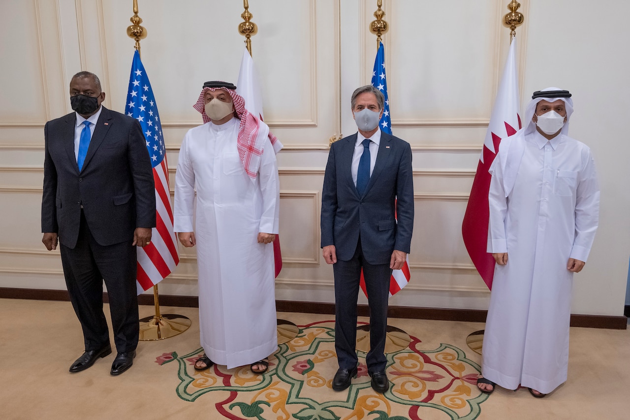 Four people stand in a row in a briefing.