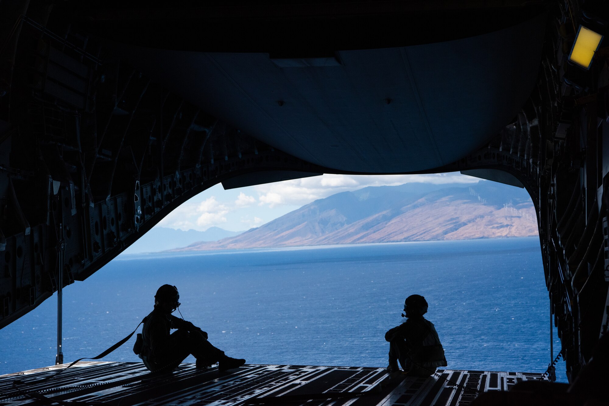 Photo of two Airmen sitting on the back of a C-17 Globemaster III.