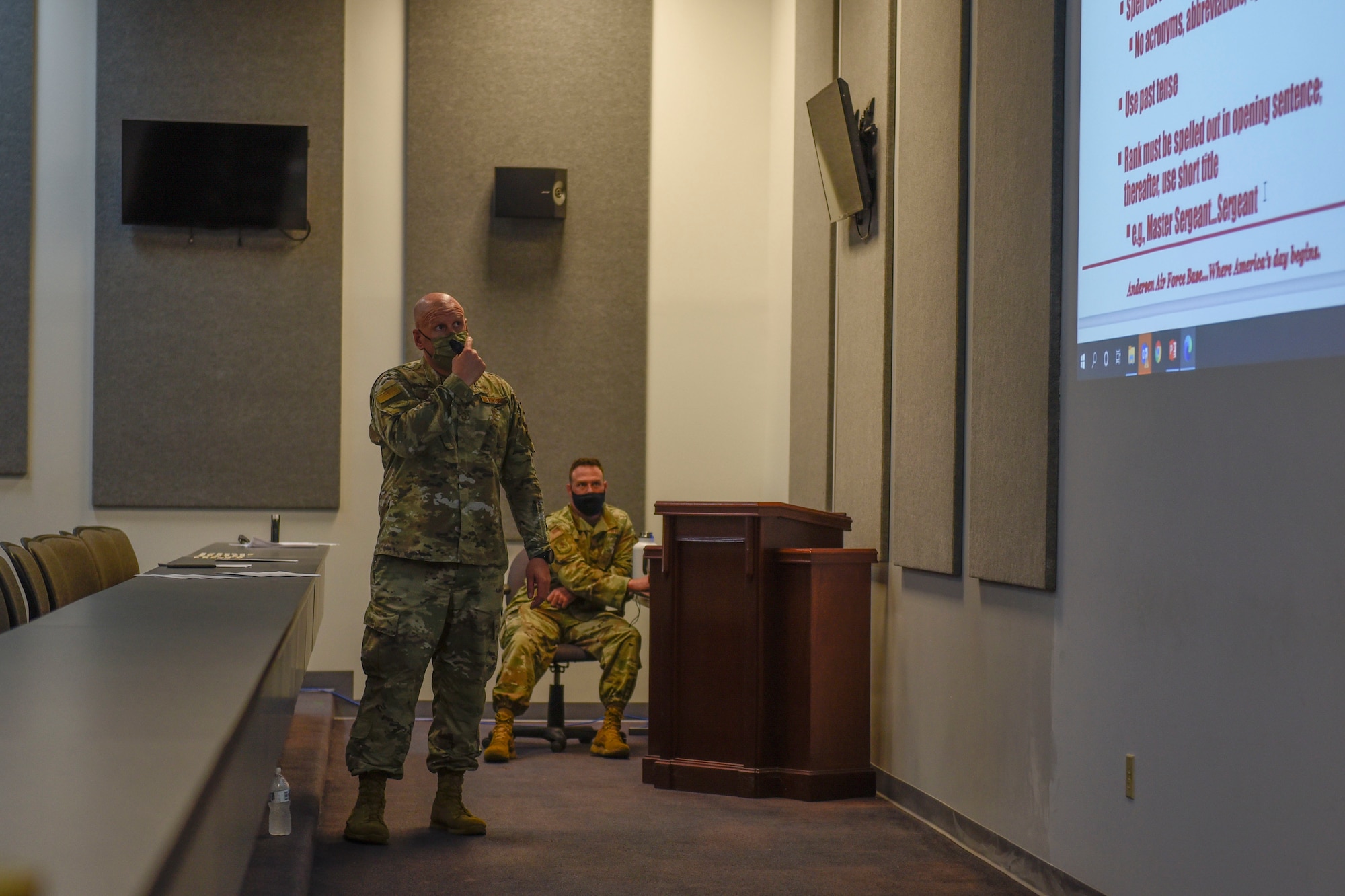 A man standing and presenting power point slides