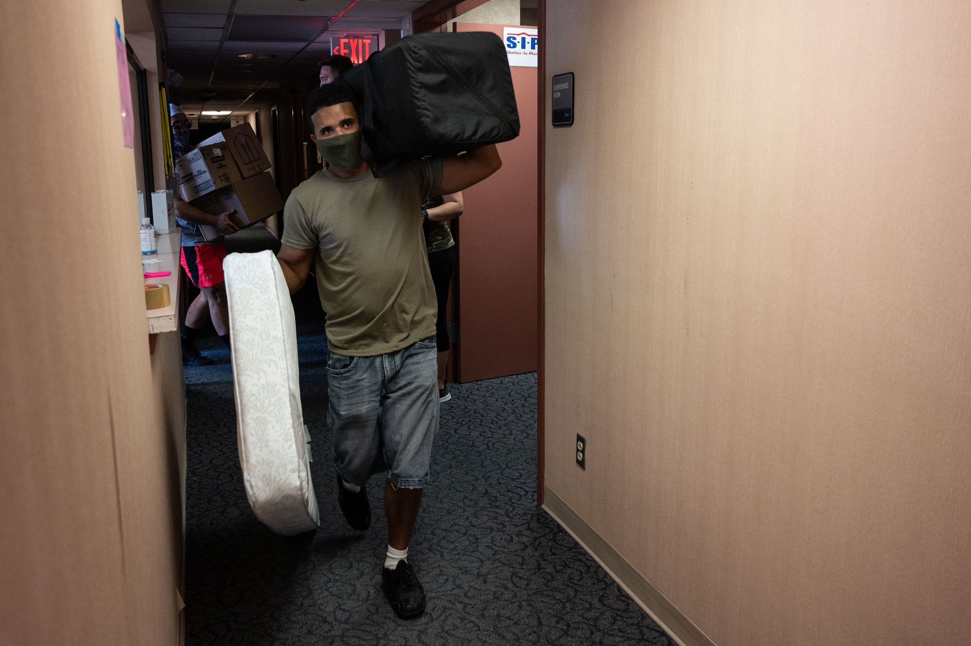 A volunteer carries a mattress and a travel crib, Sept. 3, 2021 on Holloman Air Force Base, New Mexico. A donation for Afghan refugees valued at $80,000 was collected in five days by the Cannon Key Spouse Organization in partnership with the Clovis Civic Center. The Department of Defense, through U.S. Northern Command, and in support of the Department of Homeland Security, is providing transportation, temporary housing, medical screening, and general support for up to 50,000 Afghan evacuees at suitable facilities, in permanent or temporary structures, as quickly as possible. This initiative provides Afghan personnel essential support at secure locations outside Afghanistan. (U.S. Air Force photo by Tech. Sgt. BreeAnn Sachs)