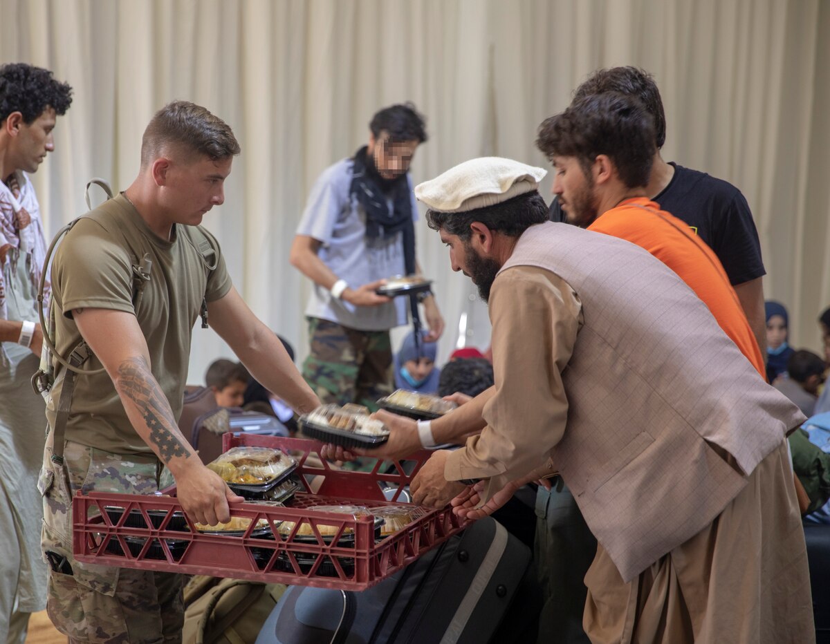 Service members provide meals to people.