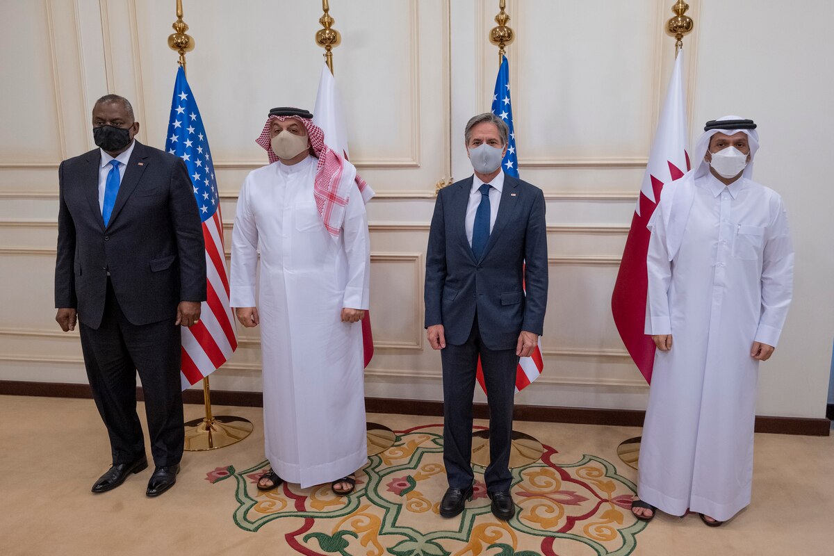 Four people stand in a row in a briefing.