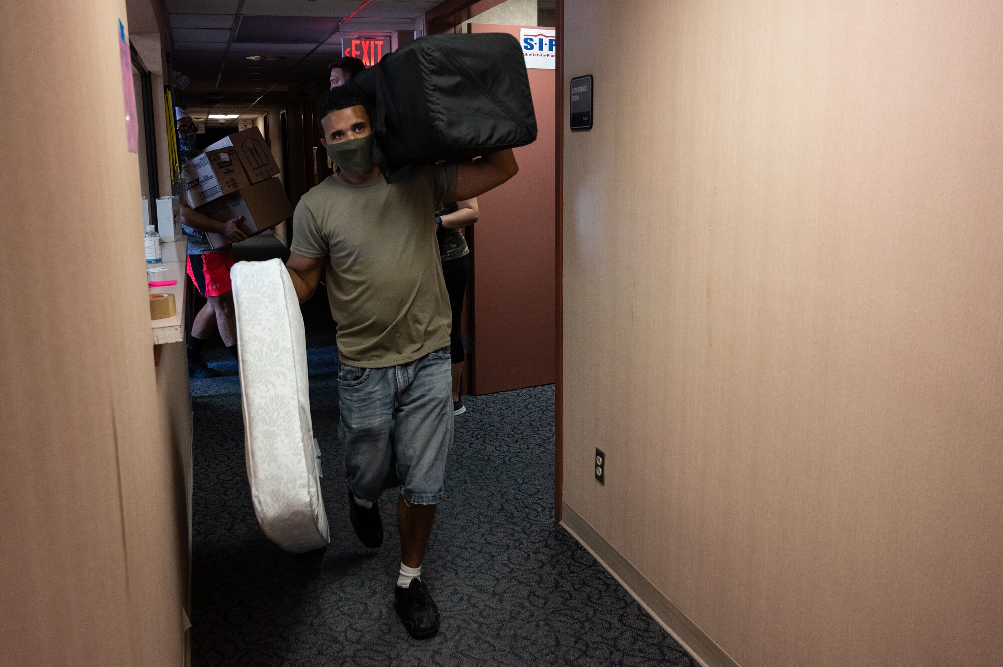 A volunteer carries a mattress and a travel crib, Sept. 3, 2021 on Holloman Air Force Base, New Mexico. A donation for Afghan refugees valued at $80,000 was collected in five days by the Cannon Key Spouse Organization in partnership with the Clovis Civic Center. The Department of Defense, through U.S. Northern Command, and in support of the Department of Homeland Security, is providing transportation, temporary housing, medical screening, and general support for up to 50,000 Afghan evacuees at suitable facilities, in permanent or temporary structures, as quickly as possible. This initiative provides Afghan personnel essential support at secure locations outside Afghanistan. (U.S. Air Force photo by Tech. Sgt. BreeAnn Sachs)