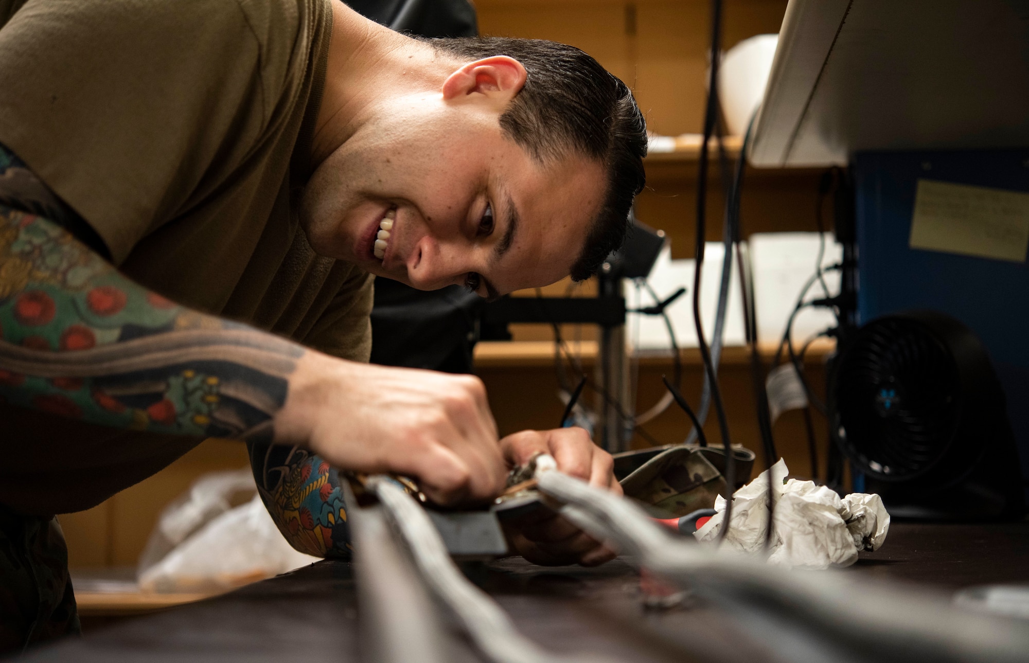 An Airmen fixes a jet component.