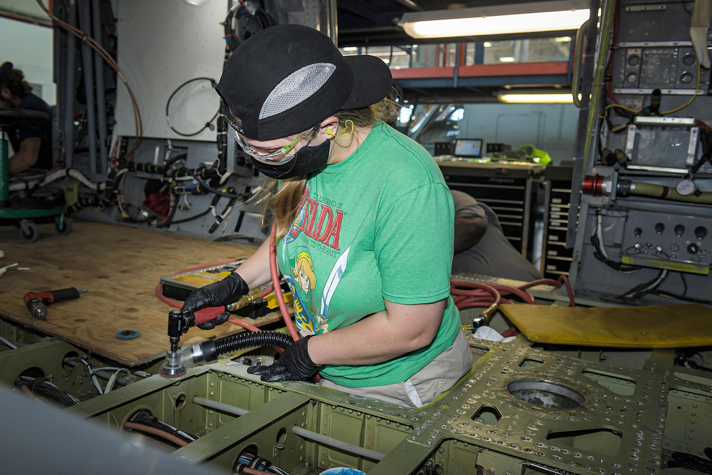 Carlie Lee, a sheet metal mechanic apprentice assigned to Fleet Readiness Center Southeast’s Vertical Lift Production line, performs corrosion control maintenance on an H-60 aircraft.