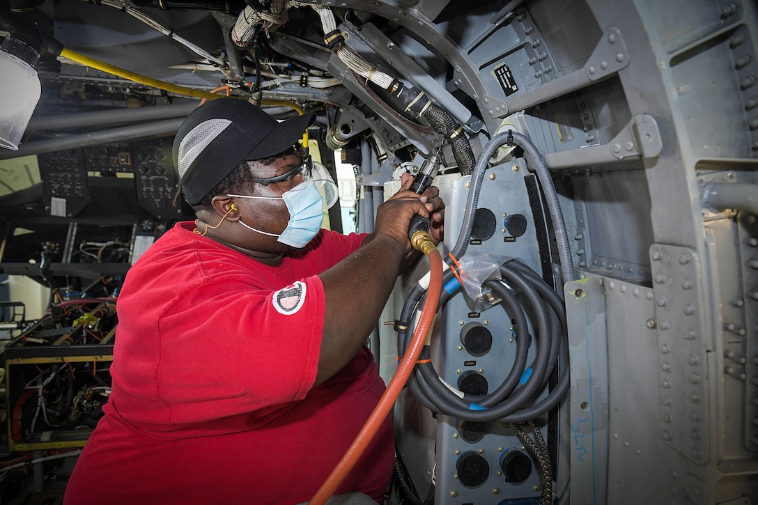 Gambriel Newberry removes duct panels from an H-60 aircraft.