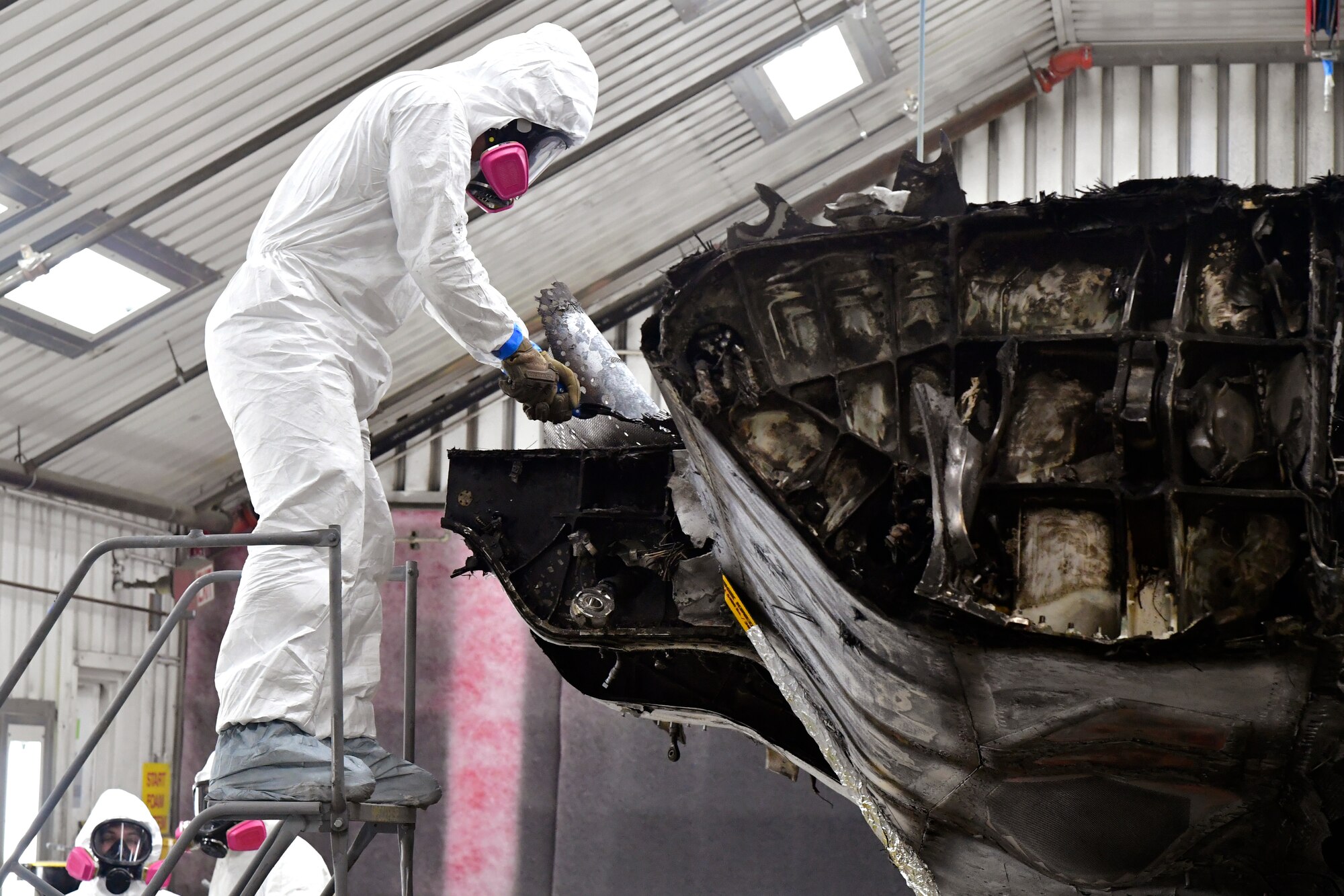 Airman 1st Class Evander Esperanza, 388th Maintenance Squadron corrosion control, works to remove ragged edges of carbon fiber on a condemned F-35A Lightning II Aug. 2, 2021, at Hill Air Force Base, Utah. The aircraft was involved in a landing mishap in 2020 at Eglin AFB, Florida, but is now being transformed into sectional training aids by Airmen at Hill AFB for use during instruction of F-35 maintainers. (U.S. Air Force photo by Todd Cromar)