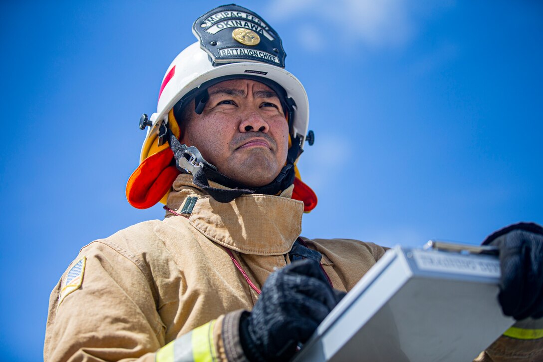 Takeshi Tsuhako, the battalion training chief with Marine Corps Installations Pacific Fire and Emergency Services, supervises a performance evaluation on Camp Hansen, Okinawa, Japan, Aug. 25, 2021. On a daily basis, Tsuhako is responsible for regulating effective training that ensures all station personnel conduct emergency and nonemergency operations in a safe, effective, and efficient manner. In addition to this, he trains new firefighting personnel and evaluates each engine company’s fire suppression capability and their ability to maintain and improve their performance on a quarterly basis. Tsuhako is a native of Yonabaru, Okinawa, Japan. (U.S. Marine Corps photo by Lance Cpl. Alex Fairchild)