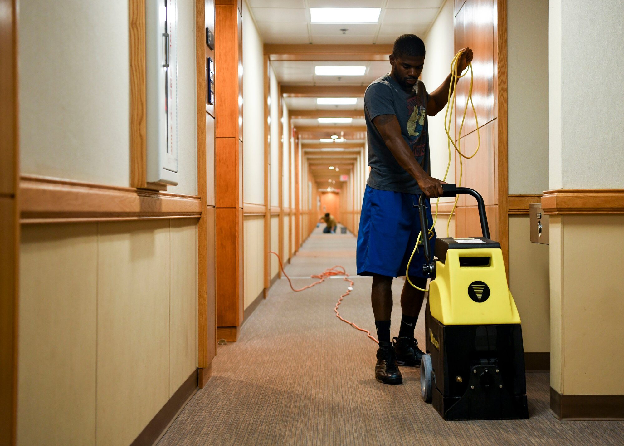 An Airman cleans carpet.