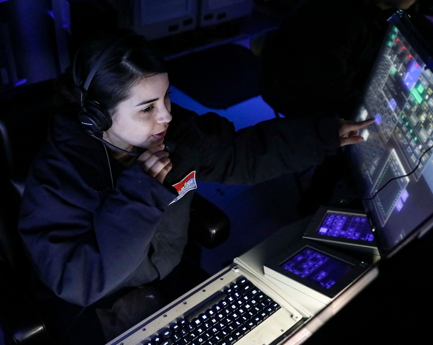 Operations Specialist 3rd Class Vanessa Castillo monitors surface contacts from the combat information center aboard USS Benfold (DDG 65) as the ship transits the South China Sea conducting routine underway operations.