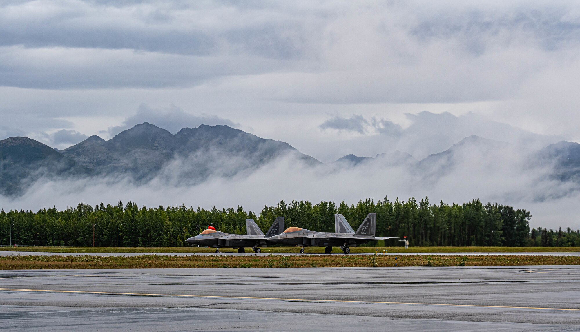 Two jets sit on a runway.