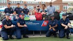 Chaplain Andrew Hoyle (standing, back left), Coast Guard headquarters’ Partnership in Education (PIE) coordinator, along with Coast Guard and Department of Homeland Security (DHS) volunteers, pose in front of a table full of backpacks stuffed with school supplies at Anita J. Turner Elementary School during a back-to-school night event, August 26th. Hundreds of Coast Guard and DHS volunteers donated equipment or helped pack backpacks with schools supplies to support the D.C. community through St. Elizabeth’s Back-to-School backpack and supply drive (Coast Guard photo by Patrick Ferraris).