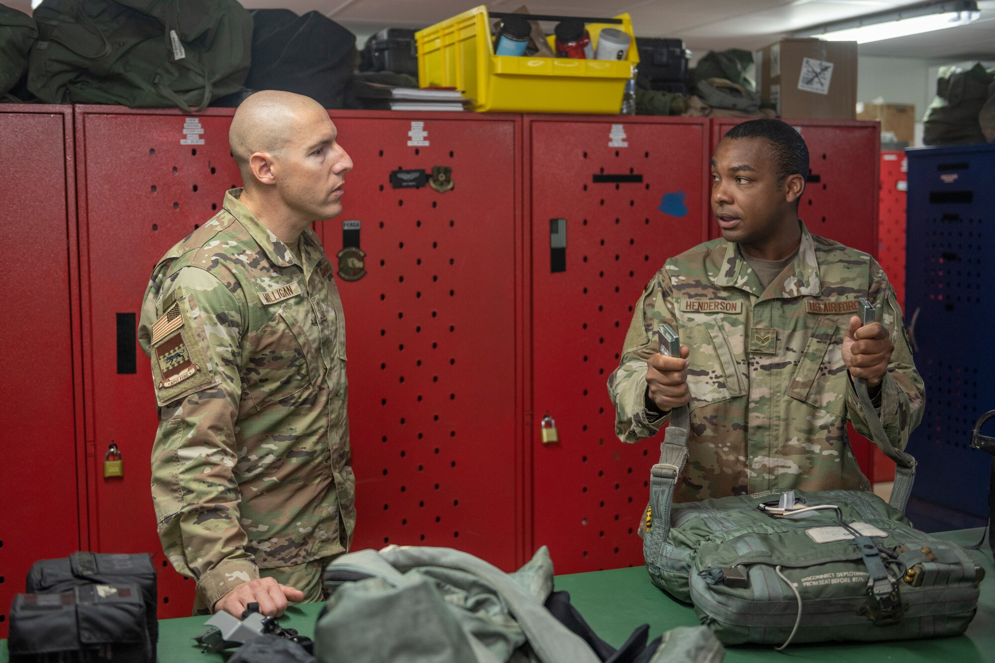 U.S. Air Force Senior Airman Caleb Henderson, right, 494th Expeditionary Fighter Squadron aircrew flight equipment technician, explains to Chief Master Sgt. Sean Milligan, 332nd Air Expeditionary Wing command chief, how to equip an Advanced Concept Ejection Seat II Survival Kit Sept. 4, 2021, at an undisclosed location somewhere in Southwest Asia. Aircrew flight equipment technicians ensure pilots are equipped with the specific gear needed to perform their missions. (U.S. Air Force photo by Senior Airman Cameron Otte)