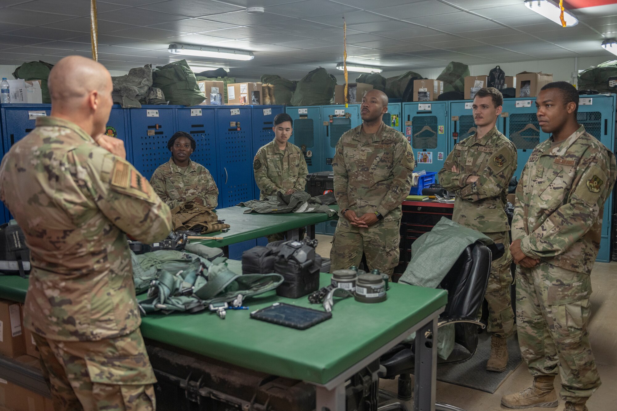 U.S. Air Force Chief Master Sgt. Sean Milligan, left, 332nd Air Expeditionary Wing command chief, interacts with the 494th Expeditionary Fighter Squadron aircrew flight equipment team Sept. 4, 2021, at an undisclosed location somewhere in Southwest Asia. Aircrew flight equipment technicians ensure pilots are equipped with the specific gear needed to perform their missions. (U.S. Air Force photo by Senior Airman Cameron Otte)