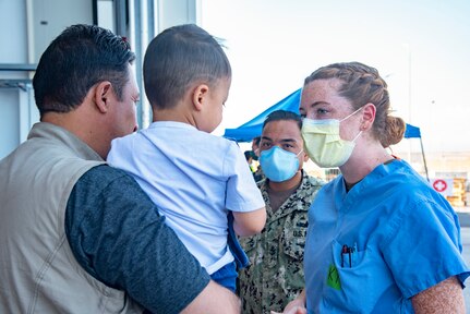 210830-N-OB360-0076 NAVAL AIR STATION SIGONELLA, Italy (Aug. 30, 2021) Lt. j.g. Katherine Harbaugh, a Kokomo Ind. native and nurse assigned to Navy Medicine Readiness and Training Command San Diego assesses the needs of an evacuee from Afghanistan aboard Naval Air Station Sigonella, Aug. 27, 2021. NAS Sigonella is currently supporting the Department of State mission to facilitate the safe departure and relocation of U.S. citizens, Special Immigration Visa recipients, and vulnerable populations from Afghanistan. (U.S. Navy photo by Chief Mass Communication Specialist Ben Farone)