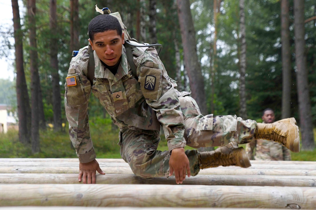 A soldier jumps over an obstacle.