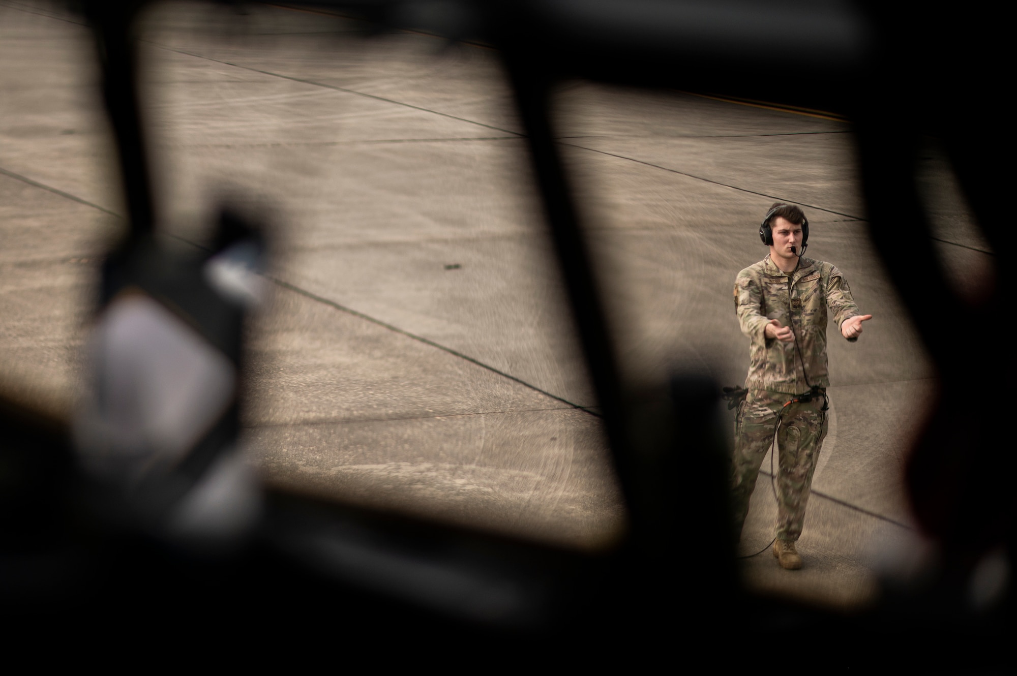 U.S. Air Force Airman 1st Class Jackson McCool, 71st Rescue Squadron HC-130J loadmaster, directs crew chiefs to remove aircraft chocks on the flight line at Moody Air Force Base, Georgia, Aug. 29, 2021. The 71st RQS provided airlift for the 822nd Base Defense Squadron’s deployment. The 822nd BDS were tasked to provide an enhanced security presence at Holloman Air Force Base, New Mexico, in support of Task Force – Holloman. The Department of Defense, through U.S. Northern Command, and in support of the Department of Homeland Security, is providing transportation, temporary housing, medical screening, and general support for at least 50,000 Afghan evacuees at suitable facilities, in permanent or temporary structures, as quickly as possible. This initiative provides Afghan personnel essential support at secure locations outside Afghanistan. (U.S. Air Force photo by Staff Sgt. Devin Boyer)