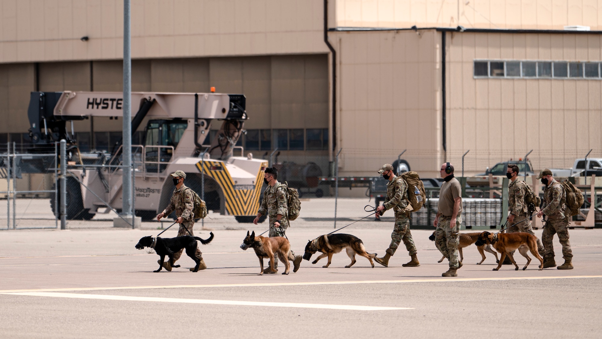 U.S. Air Force Airmen assigned to the 822nd Base Defense Squadron K-9 unit proceed to an in-processing line after arriving at Holloman Air Force Base, New Mexico, Aug. 29, 2021. The 822nd BDS were tasked to provide an enhanced security presence at Holloman AFB in support of Task Force – Holloman. The Department of Defense, through U.S. Northern Command, and in support of the Department of Homeland Security, is providing transportation, temporary housing, medical screening, and general support for at least 50,000 Afghan evacuees at suitable facilities, in permanent or temporary structures, as quickly as possible. This initiative provides Afghan personnel essential support at secure locations outside Afghanistan. (U.S. Air Force photo by Staff Sgt. Devin Boyer)