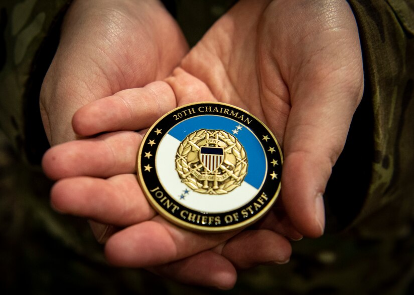 Photo of an Airman holding a coin from U.S. Army Gen. Mark Milley, the 20th Chairman of the Joint Chiefs of Staff.