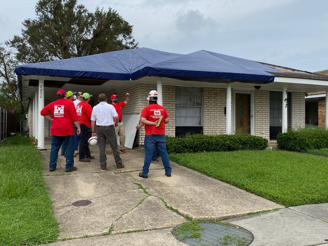U.S. Army Corps of Engineers personnel perform a pre-inspection of a house prior to USACE contractors in New Orleans install reinforced plastic sheeting as part of Operation Blue Roof .