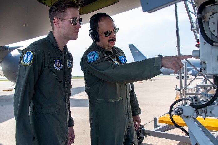 two people stand underneath aircraft