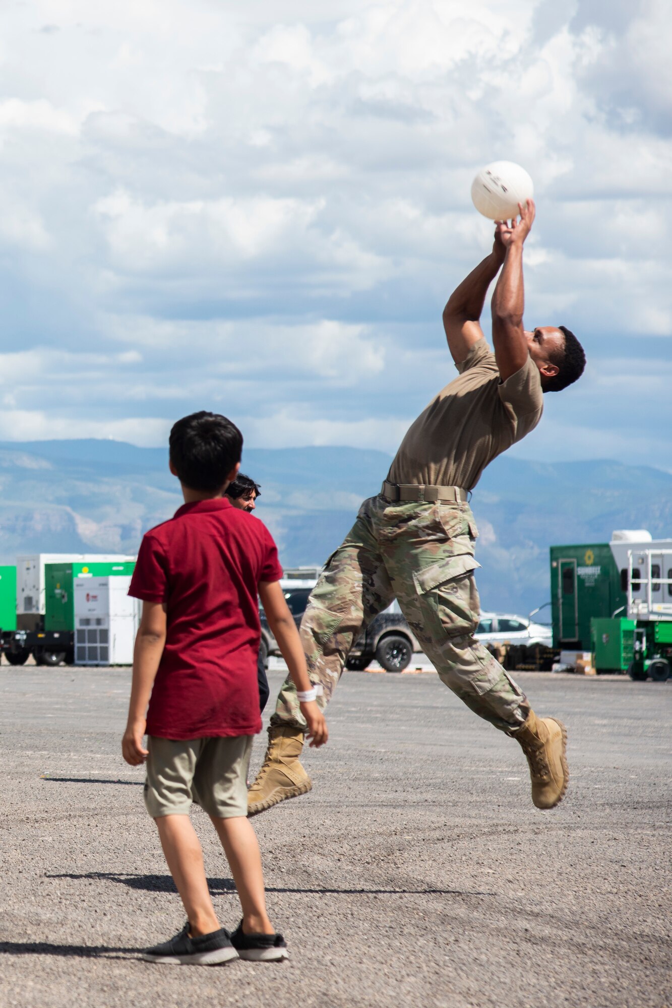 An Airman from Task Force-Holloman plays with Afghan evacuee child at Aman Omid Village on Holloman Air Force Base, New Mexico, Sept. 3, 2021. The Department of Defense, through U.S. Northern Command, and in support of the Department of State and Department of Homeland Security, is providing transportation, temporary housing, medical screening, and general support for at least 50,000 Afghan evacuees at suitable facilities, in permanent or temporary structures, as quickly as possible. This initiative provides Afghan evacuees essential support at secure locations outside Afghanistan. (U.S. Air Force photo by Capt. Daniel Rubio)