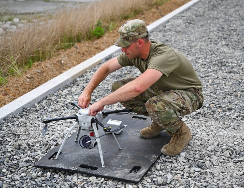 An Airman adjusts a drone during water recovery operations.