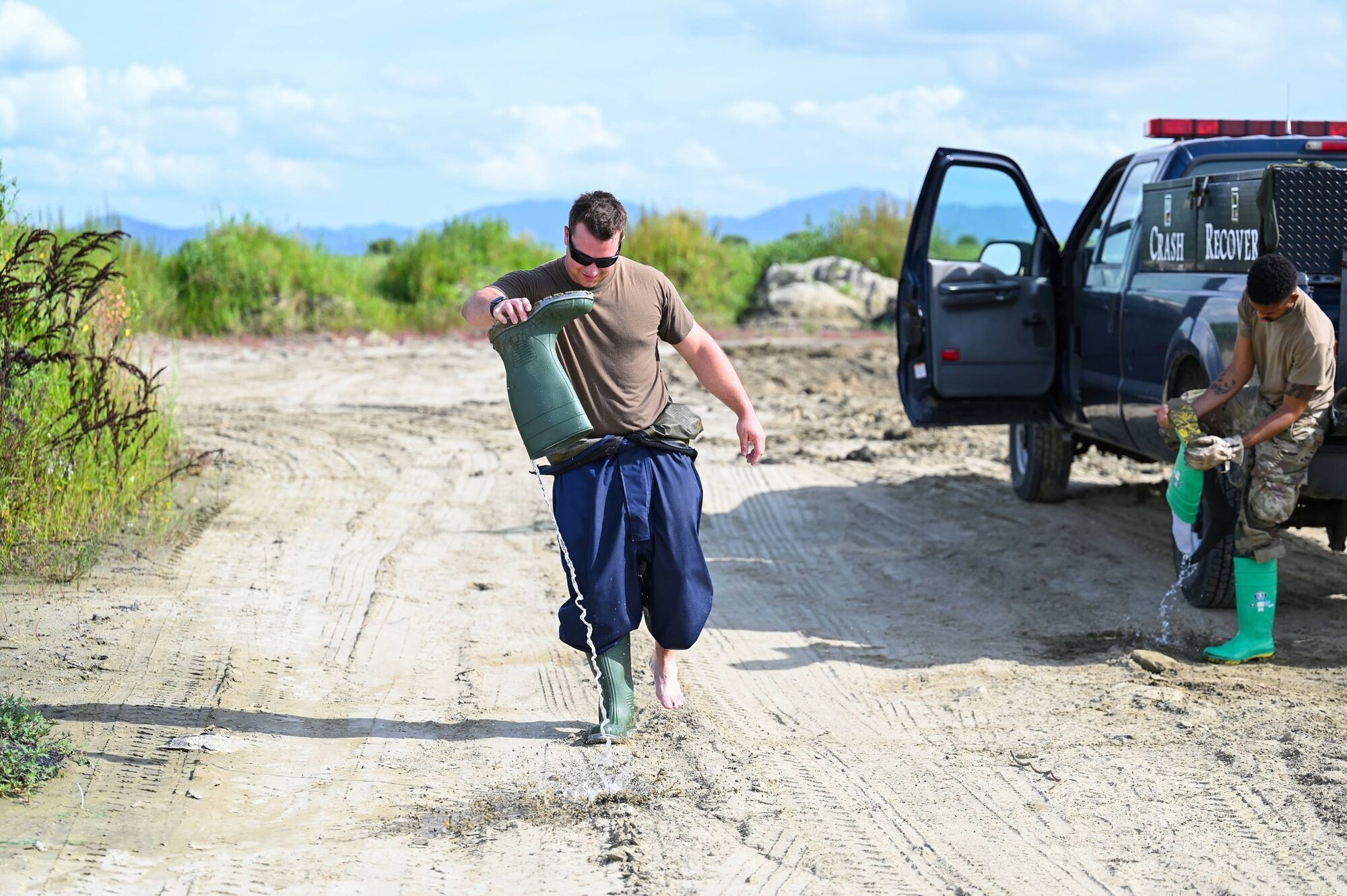An Airman pour water out of his boot.