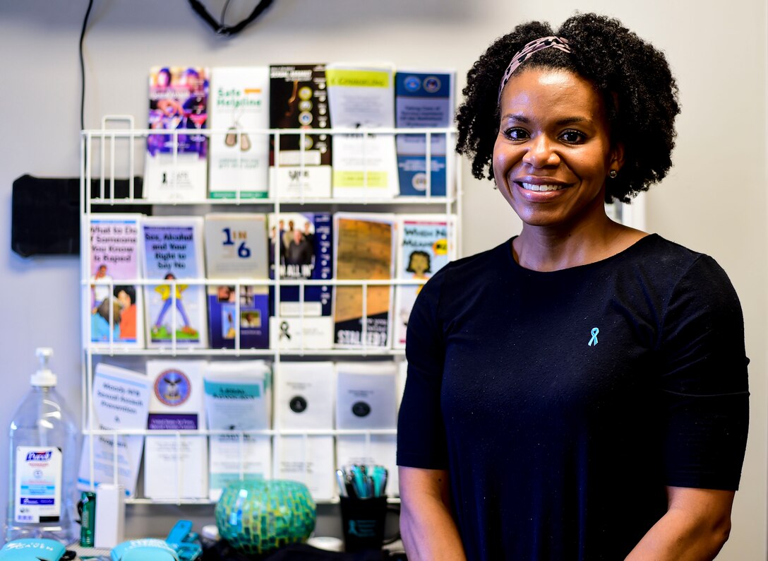 woman smiling in front of a pamphlet wall